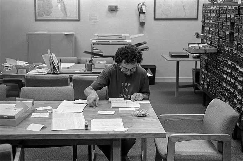 Doug Dino, researcher, viewing archival materials in the OBHC’s first Research Room, a space now used as offices, ca. 1991. David Stick’s card catalog for his library in the background. Image courtesy of Outer Banks History Center staff photos.