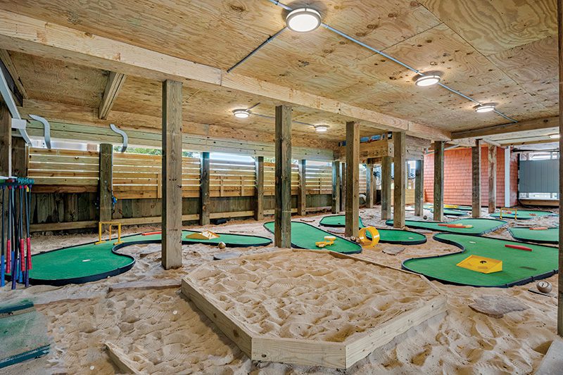 Rain or shine, the fun doesn’t stop—Atlantic Overlook’s private 9-hole mini golf course is tucked beneath the home for all-day play. Image from Carolina Designs.