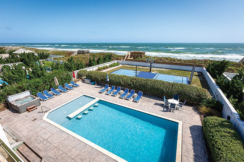 Poolside lounging, a quick game on the combination pickleball and basketball court, all within sight of the ocean. Outdoor spaces like Here Comes the Sun from Twiddy & Company are designed to keep everyone engaged from sunrise to sunset. Image from Twiddy & Company.