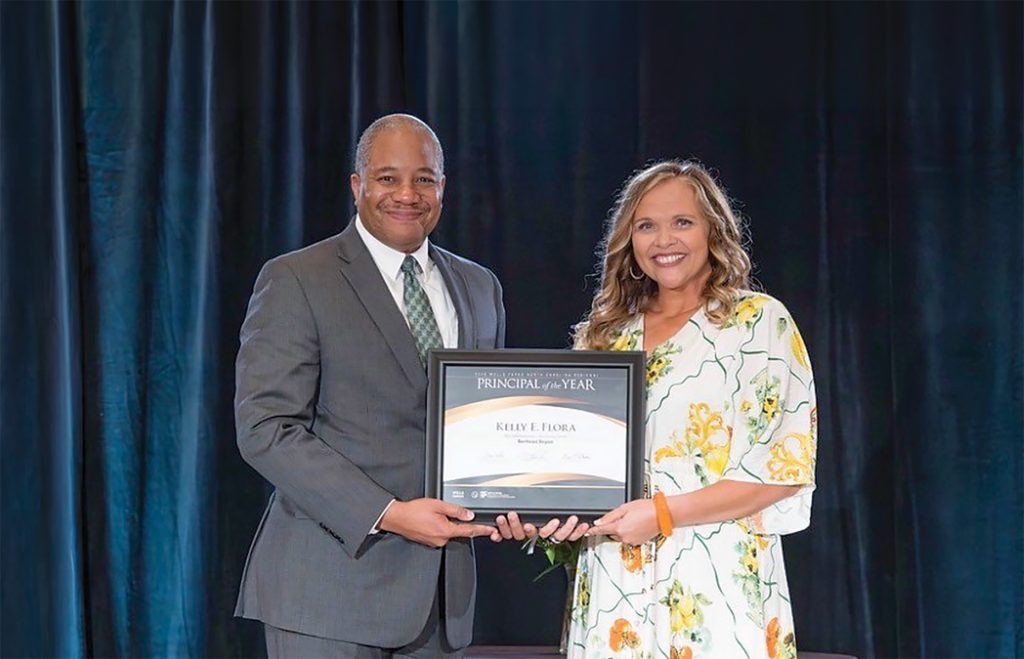 Jason Johnson, the 2025 North Carolina Principal of the Year, presents the award to Kelly Flora in a moment of honor and recognition.