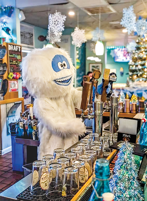 A friendly Bumble tends bar at Noosa Beach Grille, which is one of the popular "Misfits" Christmas bars that add to the festive fun.